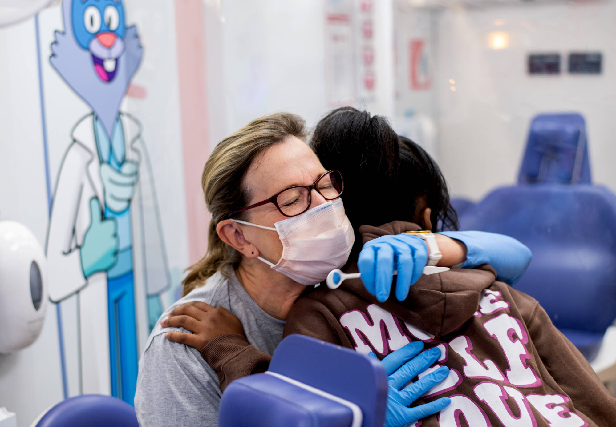 “I can go home now. It was worth it,”  said Mary Pearson, newly retired dental hygienist, left, after receiving a hug from a Stocking Elementary School student after getting an oral health screening during the Colgate Bright Smiles, Bright Futures...